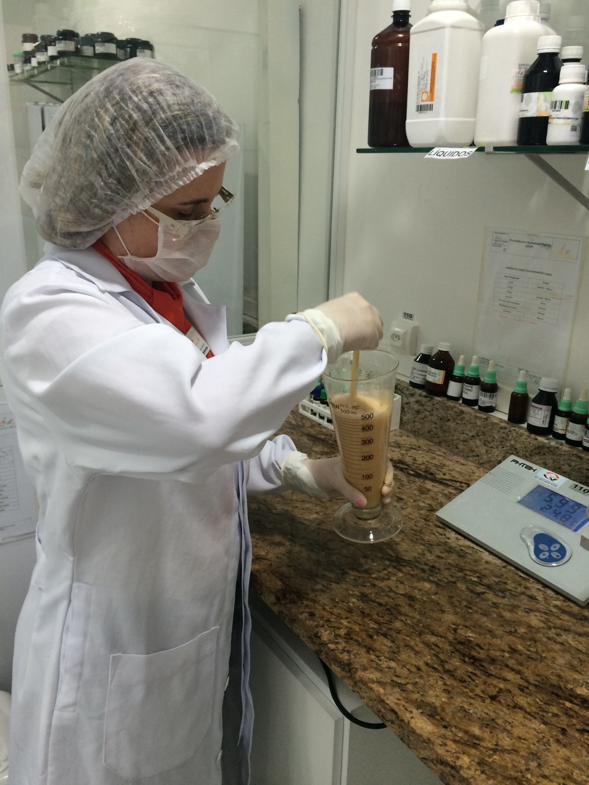 Farmacêutica de touca e jaleco manipulando uma fórmula no laboratório da VetVix